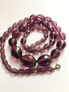 a long necklace with purple glass beads