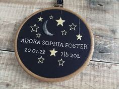 a personalized memorial ornament hanging on a wooden wall with stars and moon