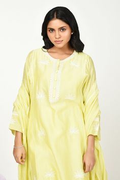 Yellow chanderi kurta with thread embroidery in floral placement pattern. Paired with cotton pant, inner and dupatta.
Components: 4
Pattern: Embroidery
Type Of Work: Thread, floral
Neckline: Round
Sleeve Type: Three quarter
Fabric: Chanderi
Color: Yellow
Other Details: 
Front button detailing
Lace embellished border
Embroidery on pant hem
Note: Potli shown in the image is not for sale
Occasion: Puja - Aza Fashions Summer Sets With Resham Embroidery In Mulmul, Mulmul Palazzo Set With Resham Embroidery And Straight Kurta, Spring Mulmul Sharara With Straight Kurta, Spring Chanderi Palazzo Set With Straight Kurta, Spring Straight Kurta With Dupatta, Mulmul Palazzo Set With Floral Embroidery, Spring Festive Mulmul Sets, Designer Kurta With Floral Embroidery In Mulmul, Designer Wear Kurta With Floral Embroidery In Mulmul