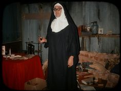 a nun standing in front of a living room