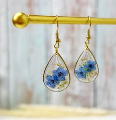 Our Forget-Me-Not Flower Tear Drop Earrings shines with 18k gold plating. Each earring holds delicate dried pressed flowers, kept safe in clear resin, and adorned with beautiful Queen Anne's lace and glittering gold flakes. 🌸 These earrings are perfect for any occasion. Whether you're going to a fancy event like a wedding or just hanging out with friends, they're the perfect accessory. They have a simple, elegant style that goes with everything from dresses to jeans.💃👖 Looking for a great gif Pressed Flower Drop Earrings, Birth Flower Drop Earrings, Queen Anne Lace, Real Flower Earrings, Fancy Event, Forget Me Not Flower, Dried And Pressed Flowers, Earrings Resin, Everlasting Love