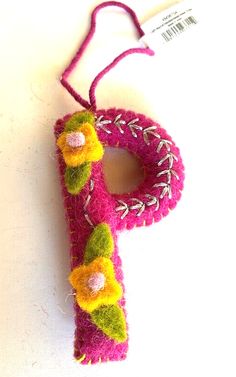 the letter p is made out of yarn and has flower decorations on it's side