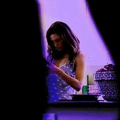 a woman standing in front of a counter with a knife and bowl on top of it