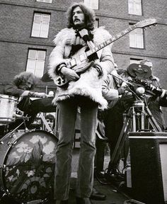 an old black and white photo of a man holding a guitar in front of other musicians