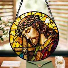 a stained glass window with jesus holding the cross in it's hands and flowers