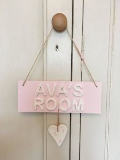 a pink sign that says ava's room hanging on a door with a heart