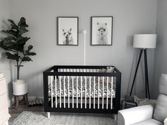 a baby's room with two pictures on the wall and a crib in the corner