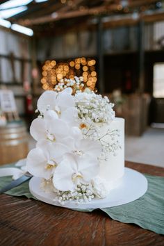 a wedding cake with white flowers and greenery