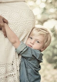 a little boy is holding his mother's belly