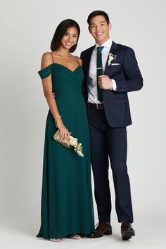 a man and woman in formal wear posing for a photo together, dressed in dark green