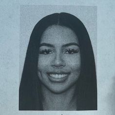 a black and white photo of a woman's face with long dark hair, smiling