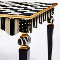 a black and white checkerboard table with gold trimmings on the top