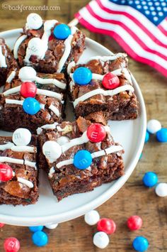 brownies with white frosting and red, white, and blue candies on a plate