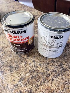 two cans of paint sitting on top of a counter