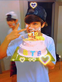 a young man holding a cake with candles on it