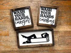 two framed signs that say wash your hands, cough and carry on top of a wooden table