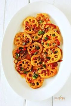 a white plate topped with sliced tomatoes covered in sauce