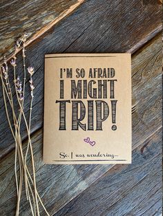 a card that says i'm so afraid i might trip on it next to some flowers