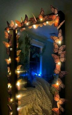 a mirror that has some lights on it in the shape of butterflies and is lit up with fairy lights