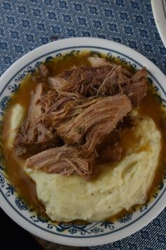 meat and mashed potatoes in gravy on a blue and white patterned plate