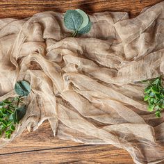 some green plants are sitting on a piece of cloth that is laying on the floor