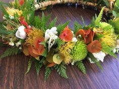 an arrangement of flowers and greenery on a table