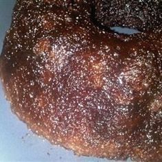 a chocolate bundt cake sitting on top of a white plate covered in powdered sugar