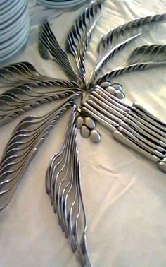 a table topped with lots of silverware on top of a white cloth covered table