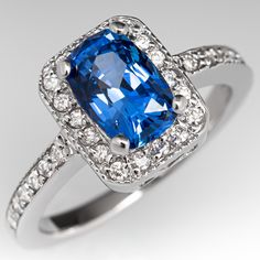 This gorgeous no heat blue sapphire ring is centered with a 1.64 carat cushion cut sapphire set into a four-prong head and is bordered with eighteen (18), bead set, round brilliant cut diamonds. The top face of the shank is accented with a row of seven (7), bead set, round brilliant cut diamonds on each side. The ring measures 10.2mm at the top, rises 6.4mm above the finger, tapering to 1.7mm wide and 1.1mm thick at the base of the shank. The ring is currently a size 4.75 and we offer compliment Blue Sapphire Engagement Ring, Blue Sapphire Ring, Sapphire Engagement Ring Blue, Sapphire Engagement Ring, Bead Set, No Heat, Blue Sapphire Rings, Sapphire Engagement, Diamond Halo