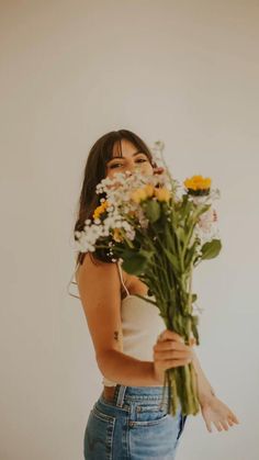 a woman is holding flowers in her hands