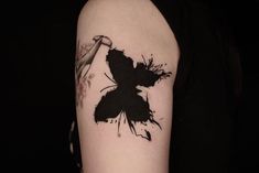 a black and white butterfly tattoo on the arm