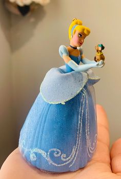 a small figurine is sitting on top of a blue dress