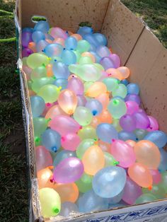 a box full of balloons in the grass