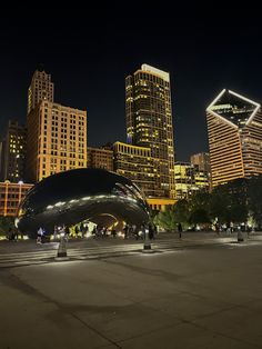 the city skyline is lit up at night with skyscrapers in the backgroud