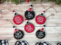 christmas ornaments are hanging on the wall with red and black plaid ribbon around them, along with other holiday decorations