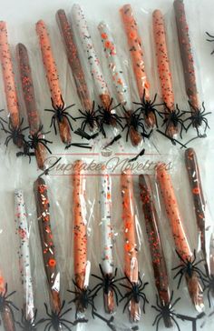 orange and white halloween candy sticks wrapped in cellophane with black spider webs