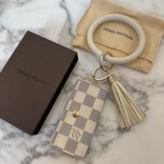 the louis vuitton key chain is next to a box