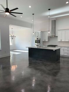 an empty kitchen with white cabinets and black counter tops is shown in the middle of this large open floor plan