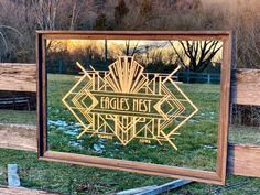 a mirror that is sitting on the ground in front of some grass and wood fence