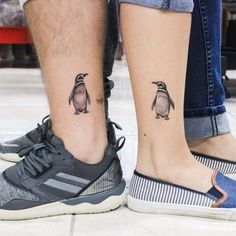 two people with tattoos on their feet standing next to each other