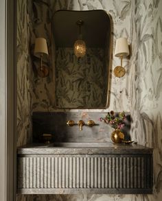 a bathroom sink sitting under a mirror next to a lamp