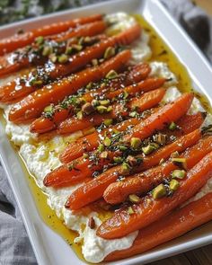 carrots and whipped cream on a plate with pistachio sprinkles