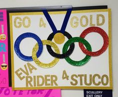 an olympic themed card with glitter on the front and gold on the back, along with a pair of eye glasses