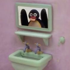 a bathroom with a sink, mirror and toy penguins