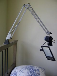 a bed with a lamp on top of it next to a wall mounted phone holder