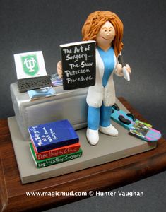 a figurine holding a sign that says the art of surgery and some books