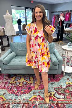 Get ready to turn heads in the playful and colorful MONICA V NECK DRESS. Featuring a flattering v neck criss cross design and flouncy ruffle cap sleeves, this dress is perfect for any occasion. Don't be afraid to stand out in this quirky and fun piece. This one runs true to size with little to no stretch. Model is wearing a small. Wash separately. Hang to dry. No bleach. Material: 100% Polyester Sizing: Small 2/4 Medium 6/8 Large 10/12 XL 14/16 Playful Pink V-neck Dress, Colorful V-neck Dress For Day Out, Multicolor V-neck Mini Dress With Ruffle Hem, Playful Short Sleeve Dresses For Brunch, Spring V-neck Dress With Flutter Sleeve And Ruffle Hem, Colorful V-neck Mini Dress, Multicolor Flutter Sleeve Dress With Ruffle Hem, Playful Multicolor Tiered Dress, Fun Flowy Spring Dresses