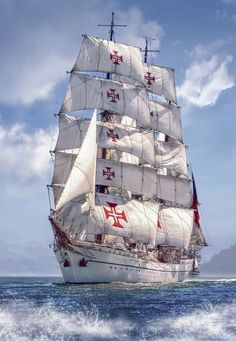 a large white sail boat sailing in the ocean