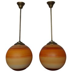 two orange and white lamps hanging from metal poles