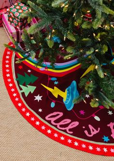 a small christmas tree in a potted planter on top of a red rug